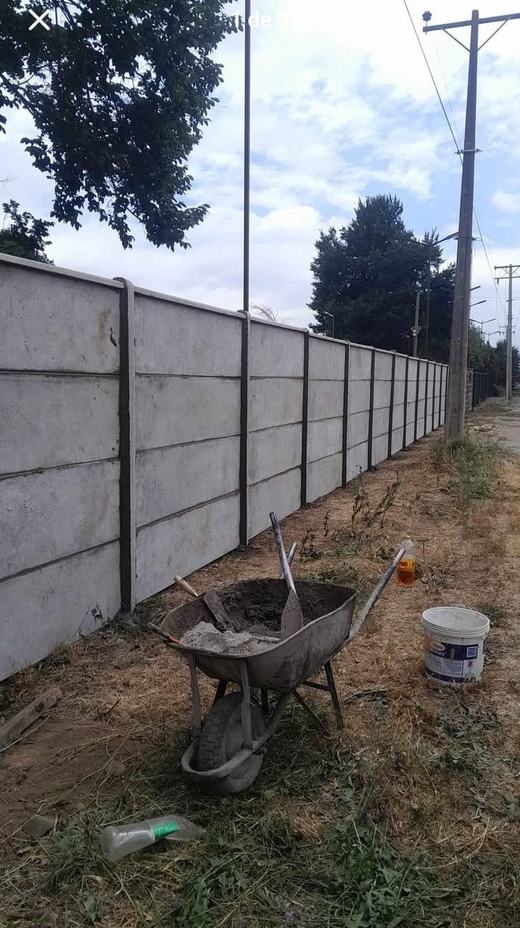 Cierre perimetral de concreto vibrado en una obra, con carretilla.
